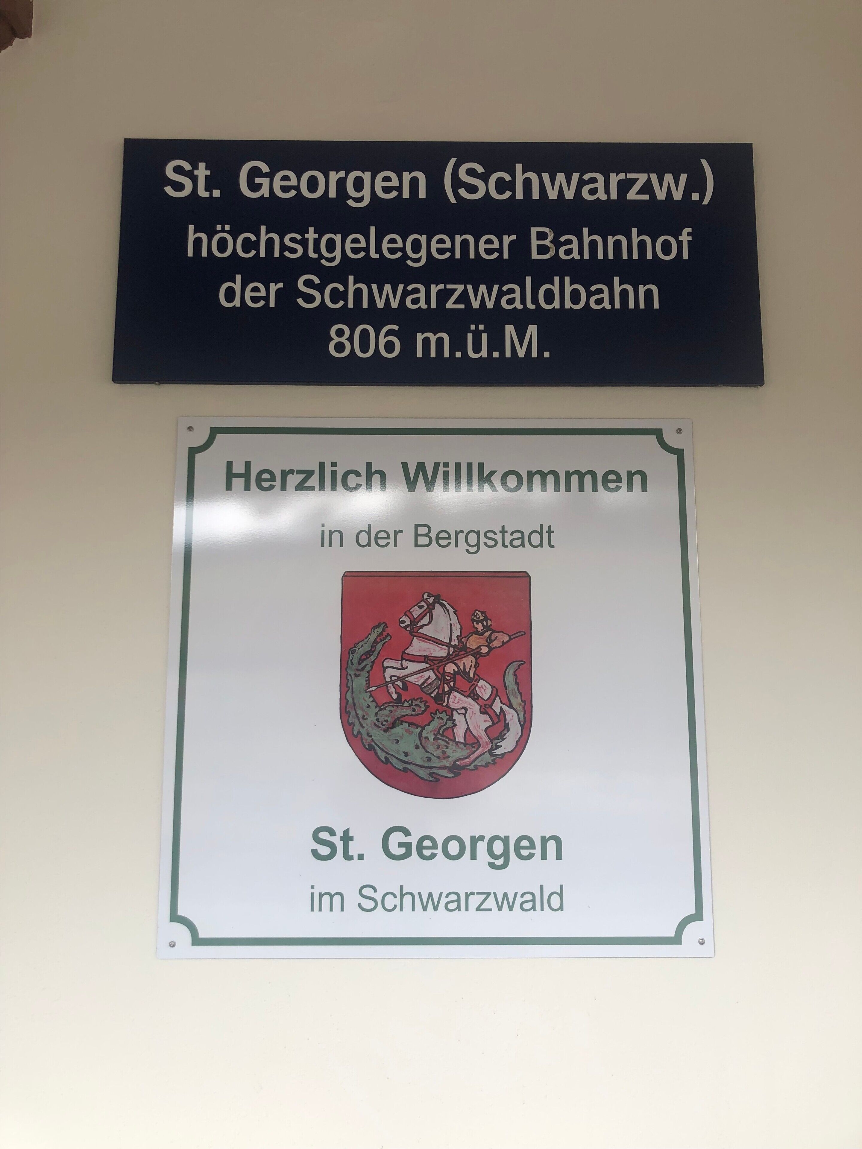 Due cartelli: uno per St. Georgen (Foresta Nera), la struttura ricettiva più alta della Schwarzwaldbahn con un numero di contatto, e un altro che accoglie i visitatori a St. Georgen nella Foresta Nera.