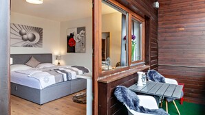 A bedroom with a bed, bedside table, lamp, and artwork.