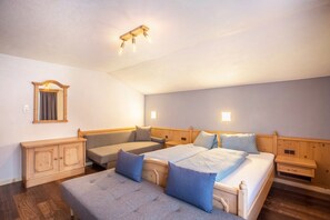 Une chambre à coucher comprenant un lit, deux tables de chevet, une armoire en bois, un canapé et un miroir.