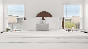 A large bed with white bedding, two nightstands with lamps, and a wooden headboard. - Orange Blossom Cottage Near Sequoias w/EV Charger (Exeter)