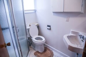 A bathroom with a toilet, sink, and a window. - Sunset House Near Sunday River Black Mountain (Rumford)