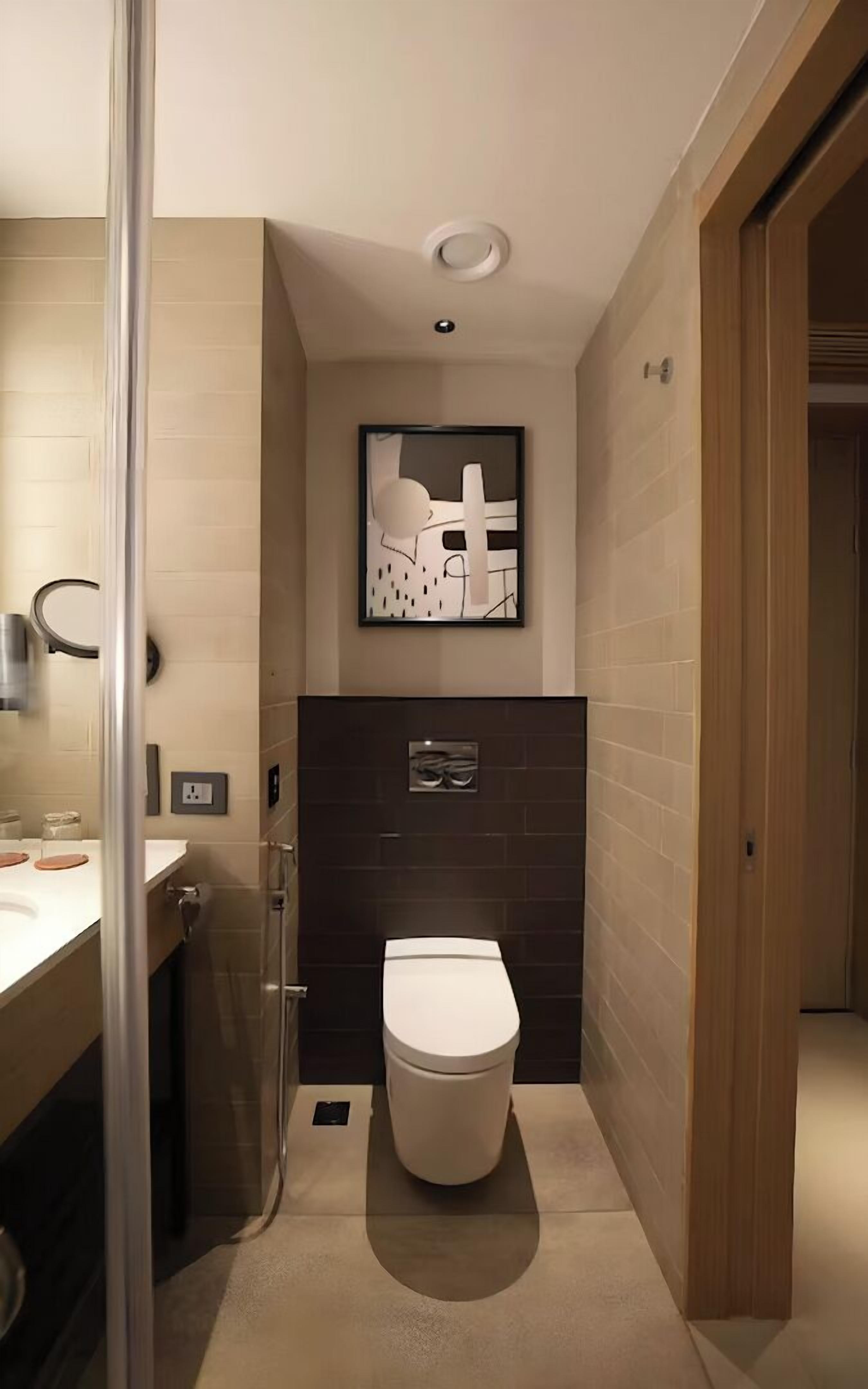 Un baño moderno con inodoro, lavamanos y ducha.