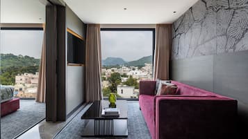 Una sala de estar moderna con un ventanal grande, un sofá rojo y un suelo estampado.