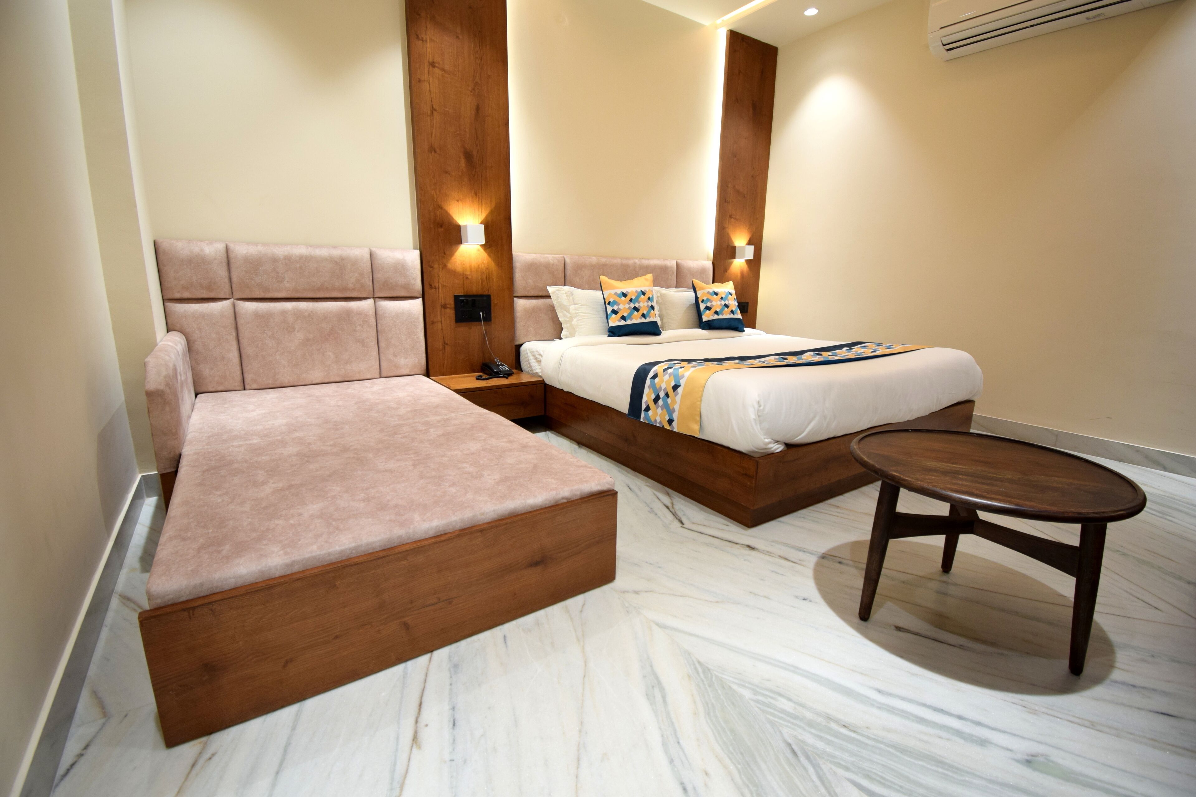 A modern bedroom with a sofa bed, a wooden bedside table, and a small round table.