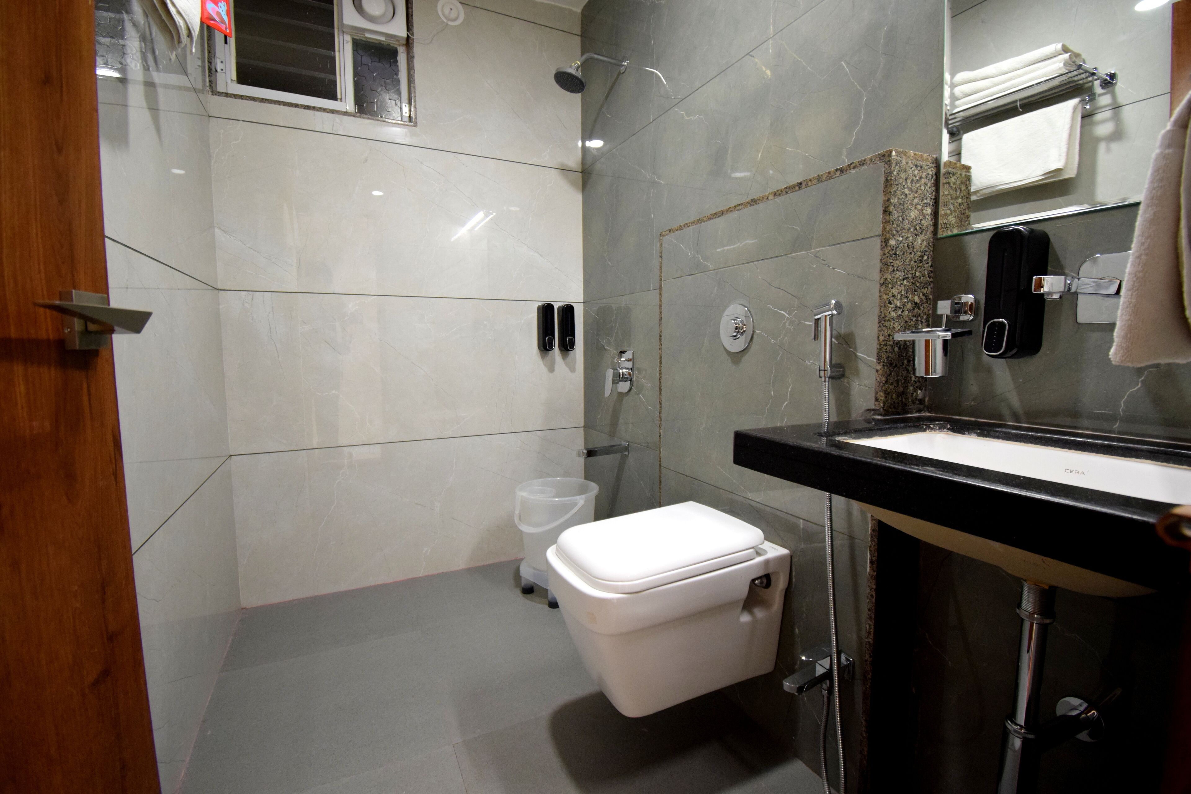 A modern bathroom with a toilet, sink, and shower.
