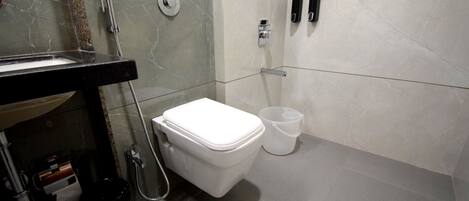 A modern bathroom with a toilet, sink, and shower.