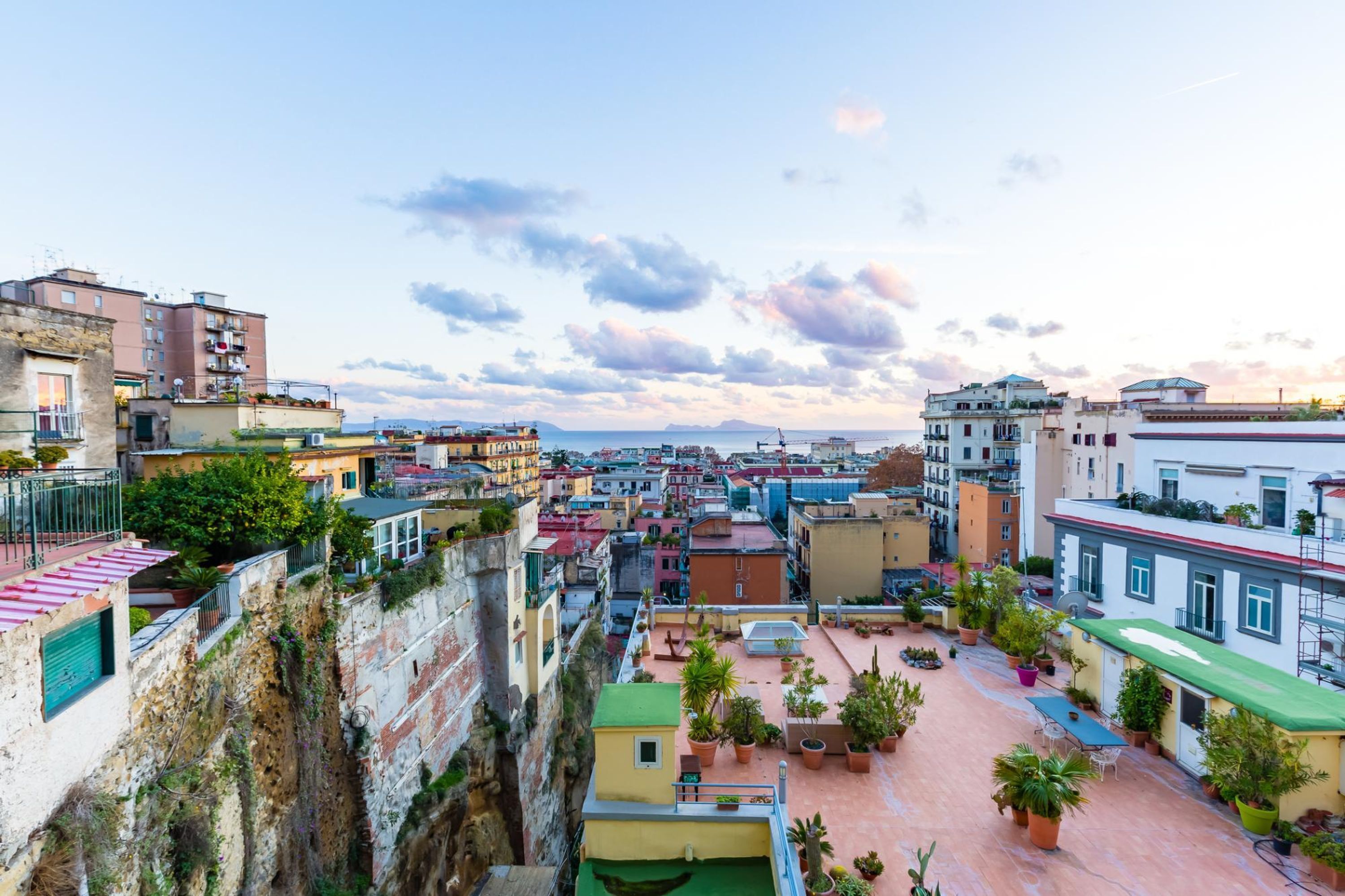 Una terrazza sul tetto con piante in vaso e posti a sedere all'aperto.
