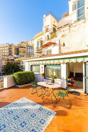 A rooftop terrace with a tiled floor, a table with chairs, and a potted plant. - Villa Paola - Hidden Panoramic Garden and Terraces (Naples)