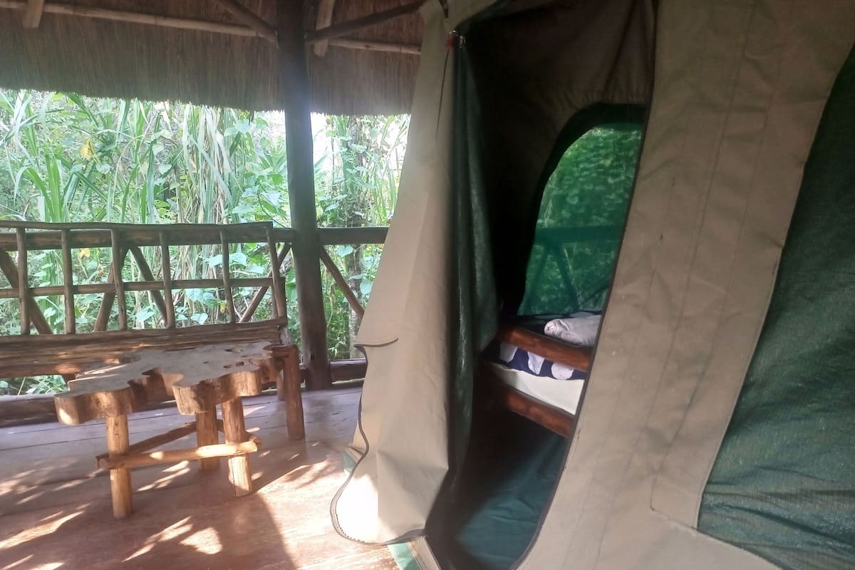 A rustic wooden cabin with a bench and a sleeping area.