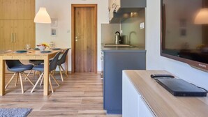 Une cuisine moderne équipée d’une cuisinière intégrée, d’un évier et d’un grand téléviseur à écran plat.