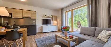 Una sala de estar moderna con un sofá, una mesa de centro y un comedor con una mesa y sillas.