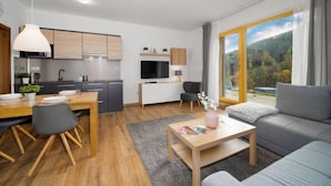 A modern apartment with a kitchen, dining area, and living room.
