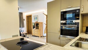 A modern kitchen with a built-in stove, oven, microwave, and a sink.