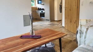 A modern kitchen with white cabinets, a built-in oven, and a microwave. - Home Fuchsbau by Interhome (See)