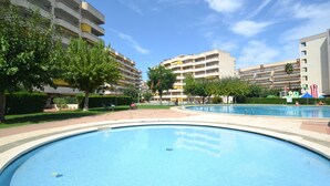 Un espace piscine avec plusieurs bâtiments en arrière-plan.