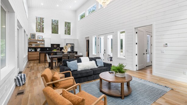 A spacious living area with a dark sofa set, a round coffee table, and a fireplace.