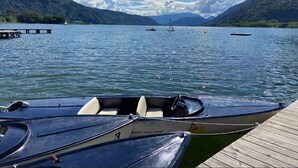A lake with boats docked on a wooden pier, surrounded by mountains. - Holiday Home Bodensdorf near Gerlitzen Ski Area (Bodensdorf am Ossiachersee)