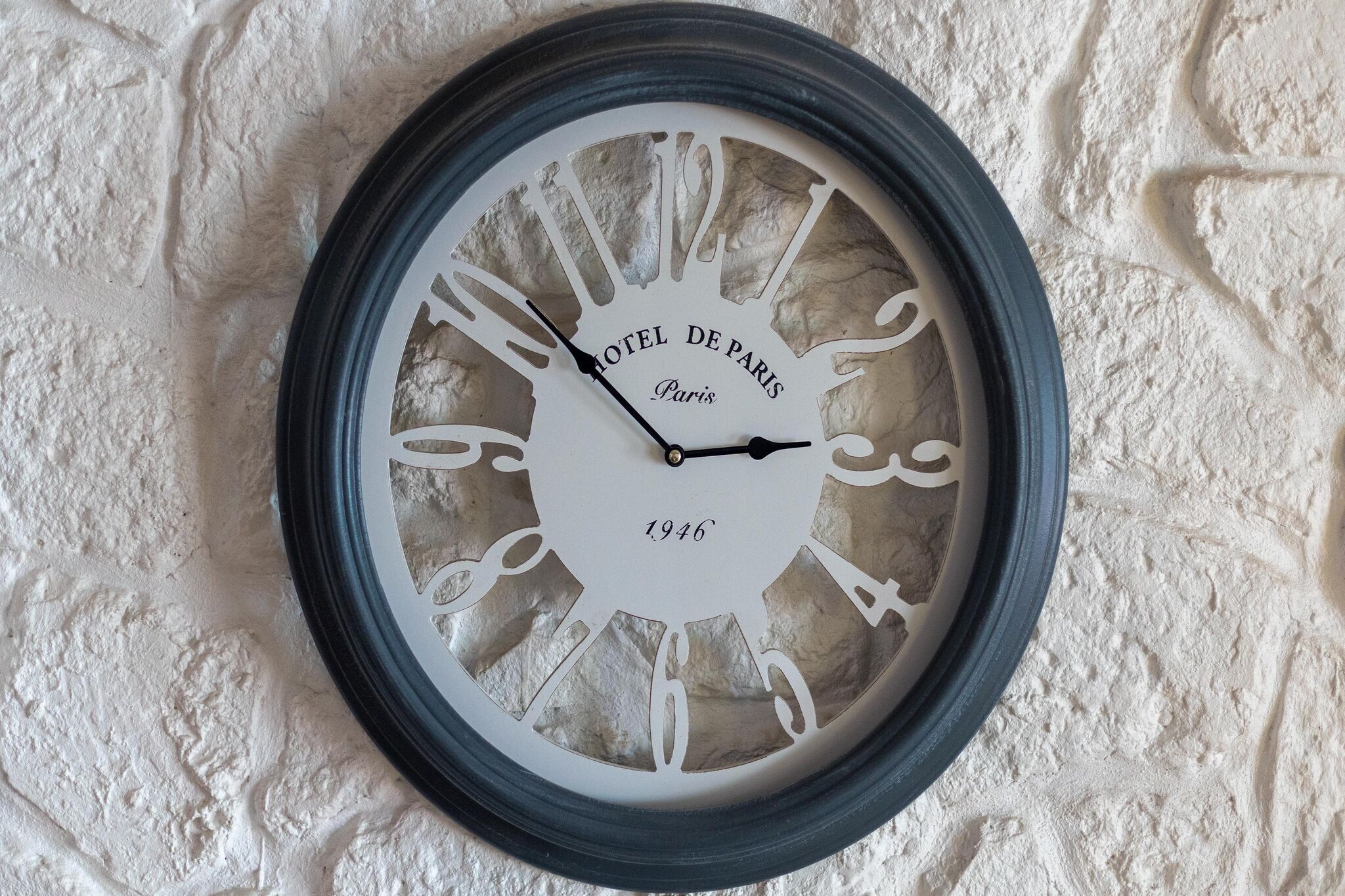 A wall-mounted clock with the inscription "HOTEL DE PARIS Paris 1946".
