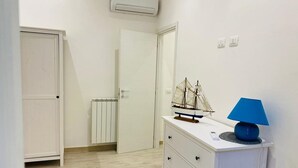 Ein Zimmer mit einem weißen Kommoden, einer blauen Lampe und einem Modellschiff darauf.