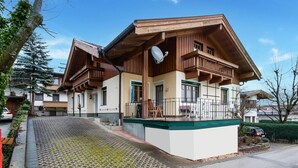A two-story wooden house with a balcony, a satellite dish, and a paved driveway. - Holiday apartment in Kaltenbach (Kaltenbach)