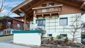 A two-story wooden house with a balcony, a small garden, and a clear sky. - Holiday apartment in Kaltenbach (Kaltenbach)