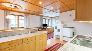 A kitchen with wooden cabinets, a granite countertop, a built-in oven, and a sink. - Holiday apartment in Kaltenbach (Kaltenbach)
