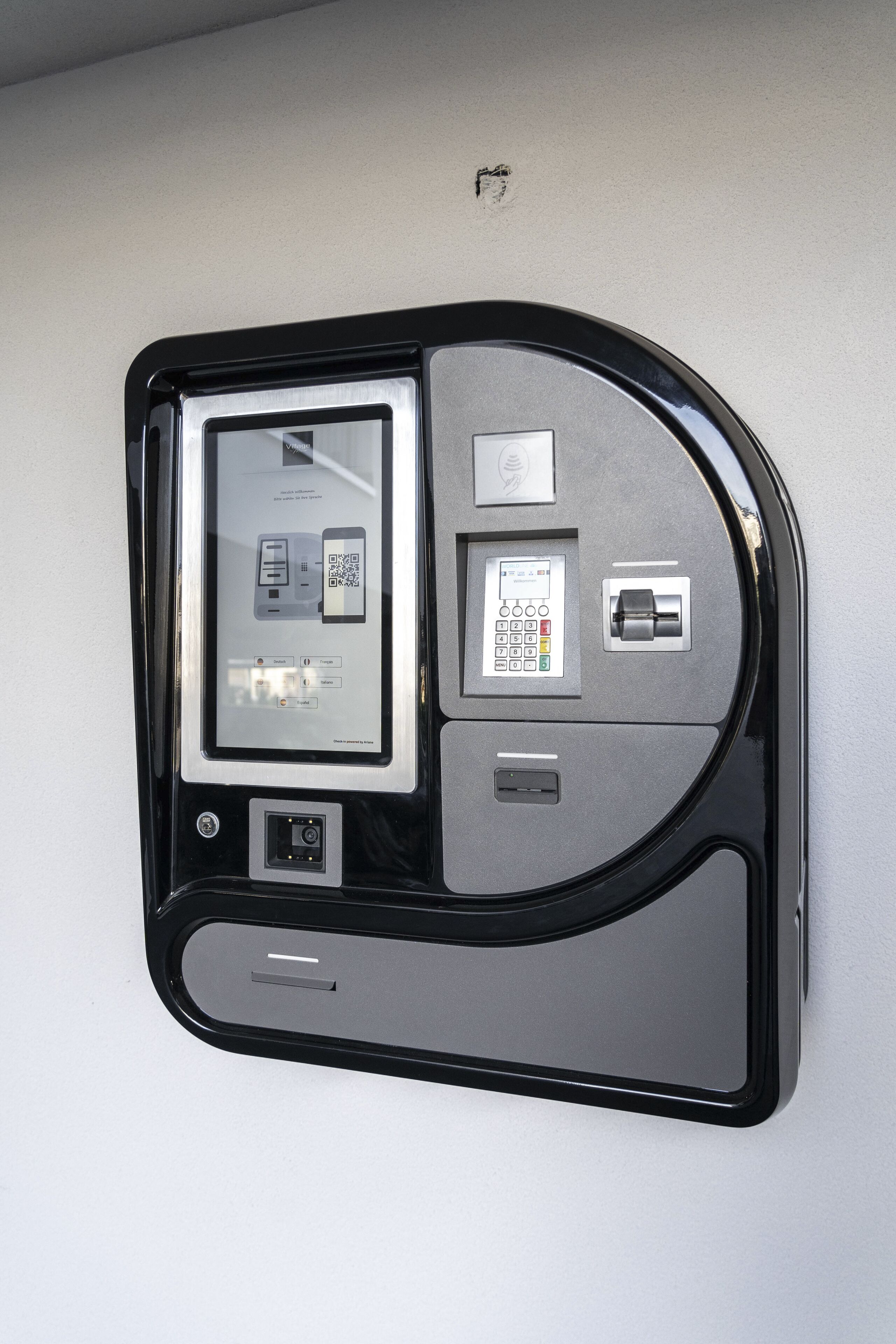 Un dispositivo electrónico fijado a la pared con un código QR, un teclado y una ranura para tarjetas.