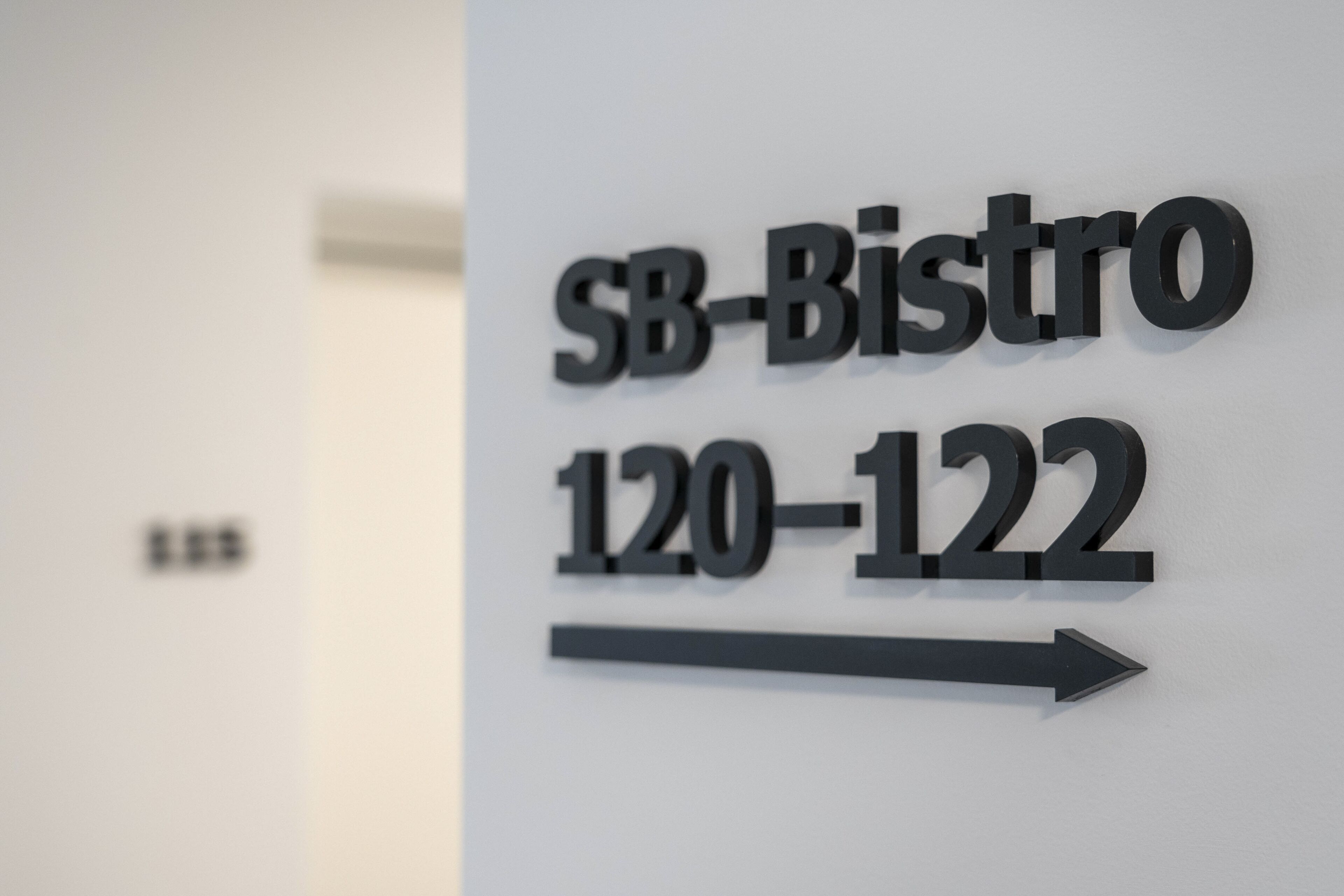 A sign for 'SB-Bistro' with the address '120-122' and an arrow pointing to the right.