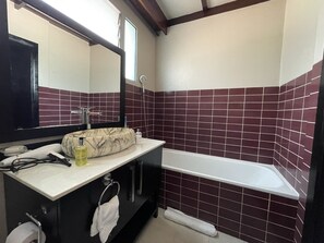 A bathroom with a marble sink, a mirror, a bathtub, and a window. - Governor's Residence (Kigali)