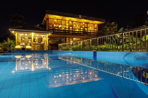 A modern hotel with a swimming pool, a bar area, and a well-lit outdoor space. - Governor's Residence (Kigali)