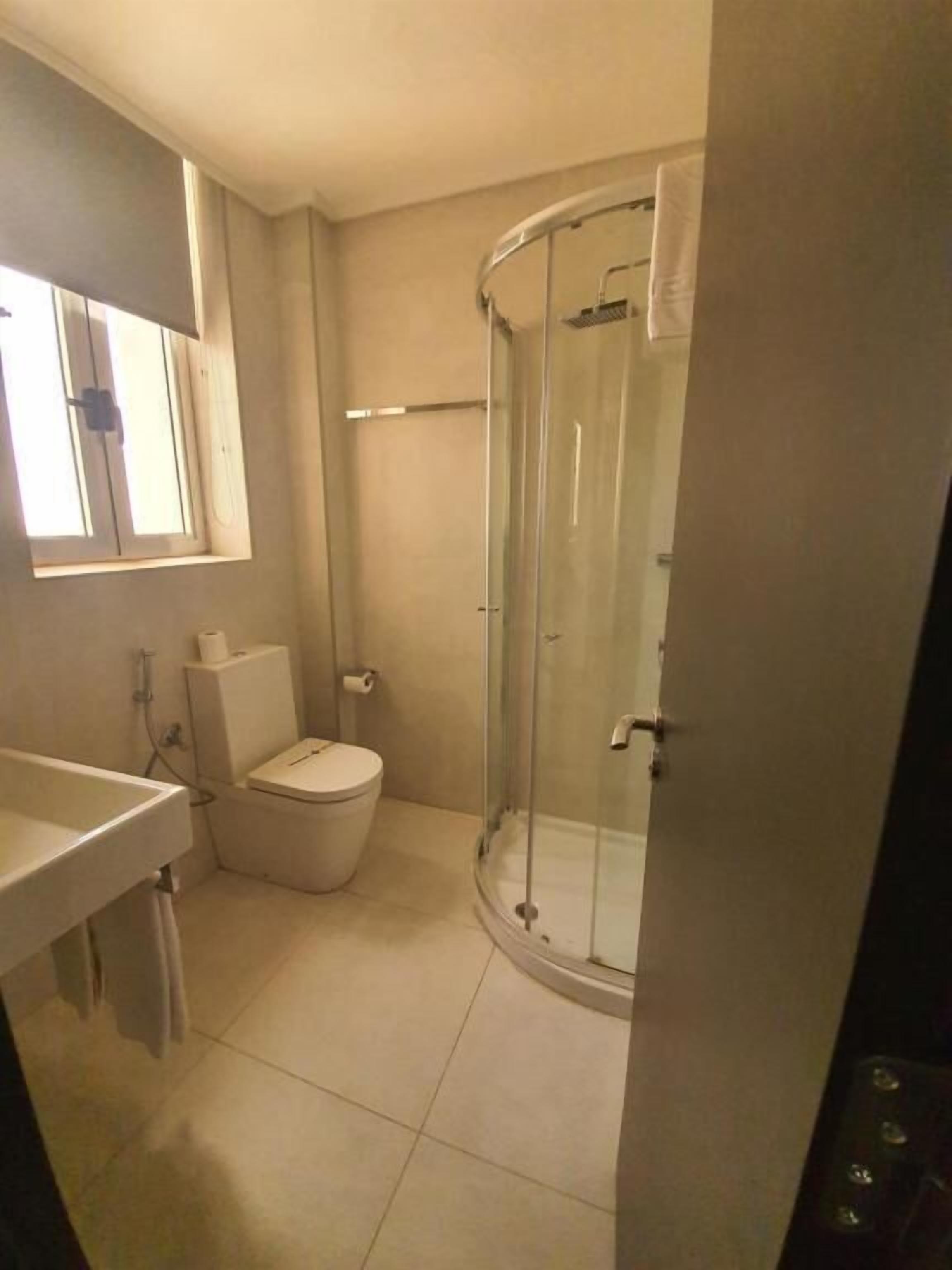 A bathroom with a toilet, sink, and a glass-enclosed shower.