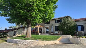 A two-story building with a covered patio and a stone pathway leading to the entrance.