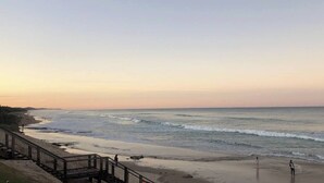 A coastal beach scene with a wooden walkway along the shore. - Spa,Fire Pit,Cinema - The Cottage Coolum Beach (Coolum Beach)