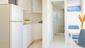 A modern kitchen with white cabinets, a built-in oven, and a small countertop with a plant. - Phaedrus Living Luxury Flat Lighthouse75 (Paphos)