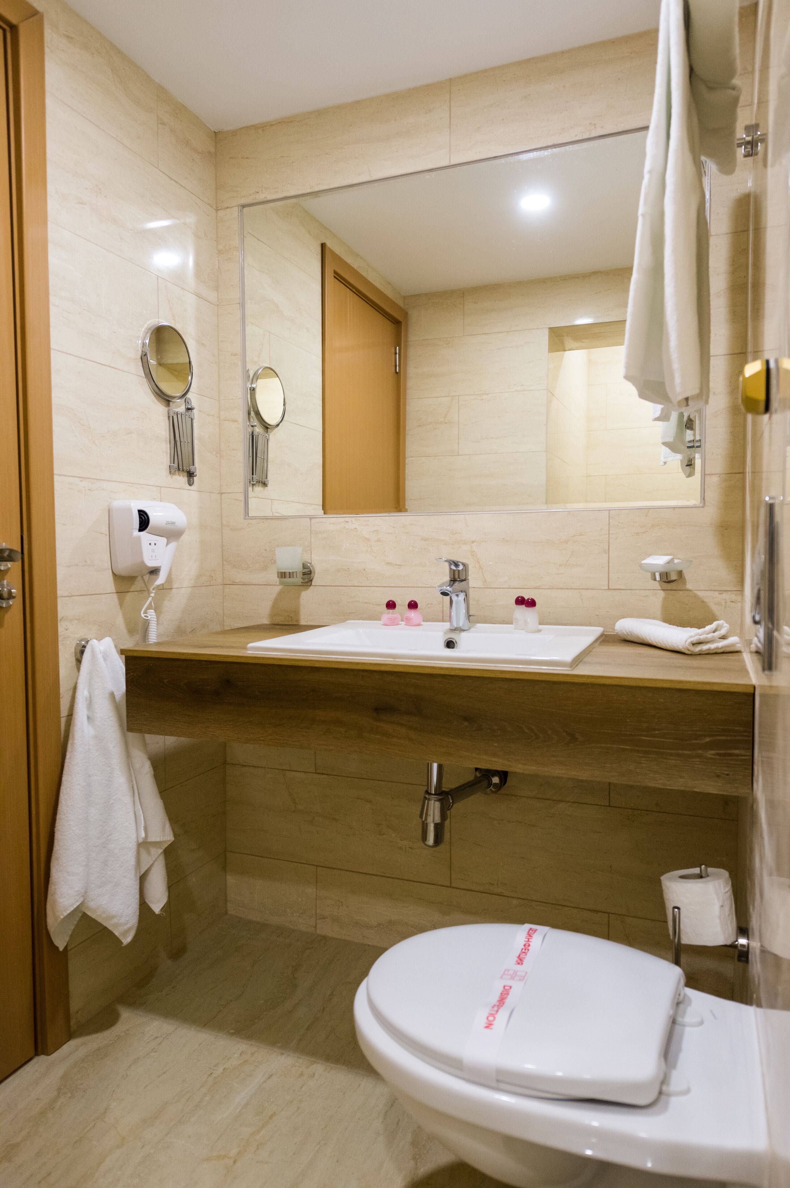 A bathroom with a sink, mirror, towel rack, and toilet.