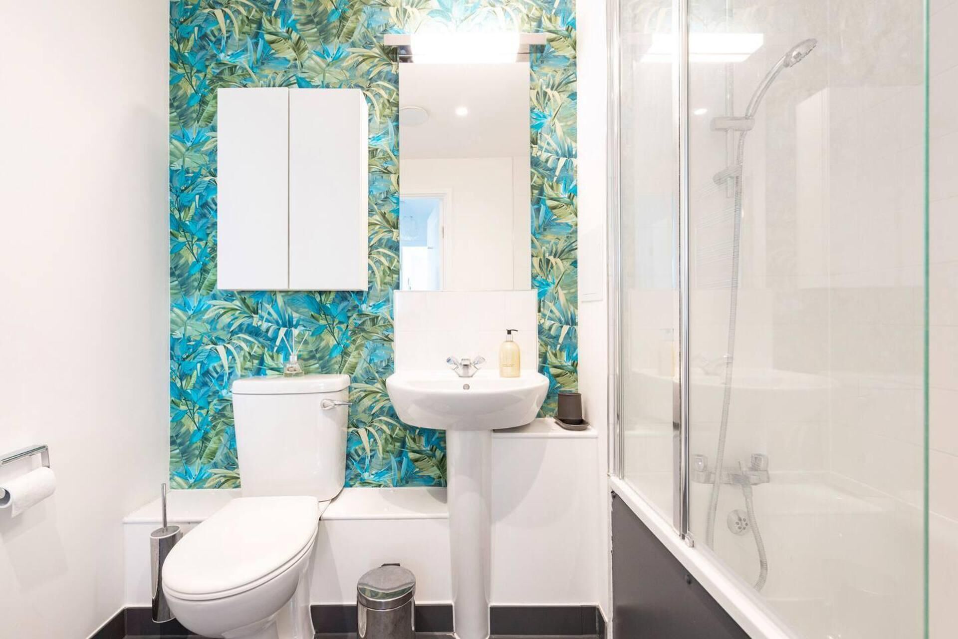 A bathroom with a toilet, sink, and glass-enclosed shower.