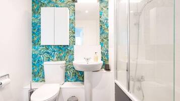 A bathroom with a toilet, sink, and glass-enclosed shower.