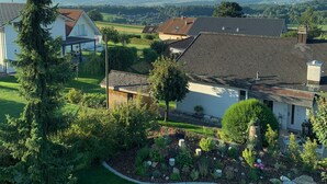 Zona residencial con casas, un árbol grande y vistas a montañas distantes.