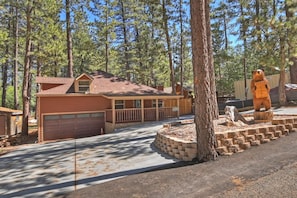 A two-story building with a garage, surrounded by trees.