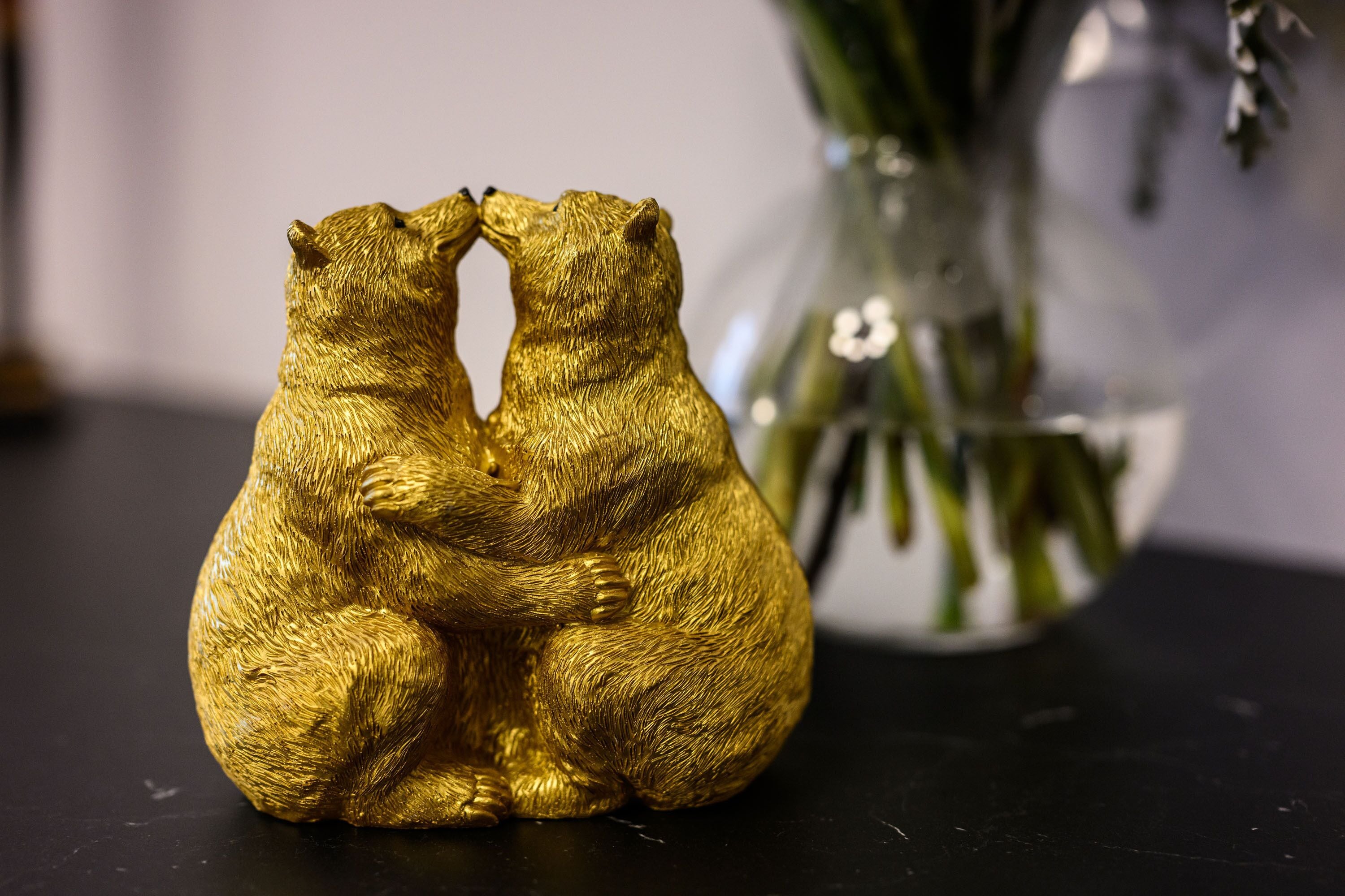 Eine goldfarbene Bärfigur auf schwarzem Untergrund.