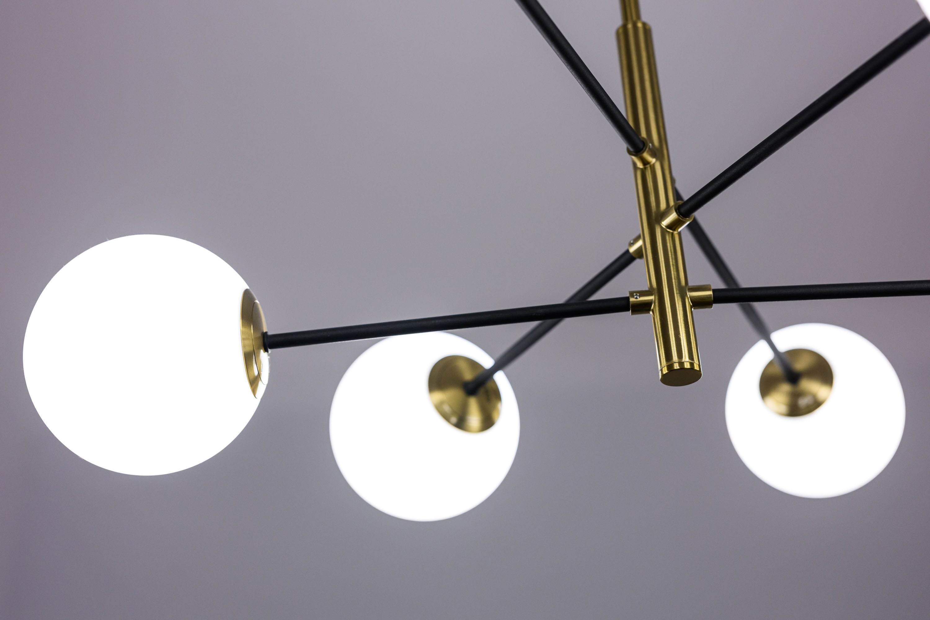 A ceiling with three spherical light fixtures and a central rod.