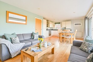 Un salon moderne avec un canapé, une table basse et un coin repas.