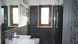 A bathroom with two sinks, a toilet, and a shower. - Bright and well-connected penthouse (Roma)