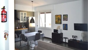 A modern apartment with a dining area, kitchen, and living space. - Bright and well-connected penthouse (Roma)