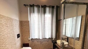 Een moderne badkamer met een bidet, toilet en wastafel.