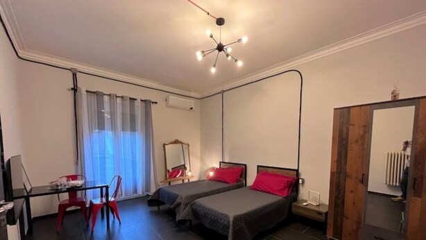 Een moderne hotelkamer met twee bedden, een bureau en een stoel.