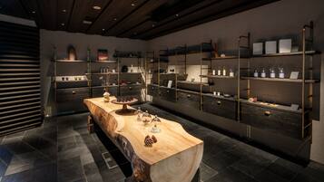 A modern kitchen with a central island, built-in shelves, and a dark tiled floor.