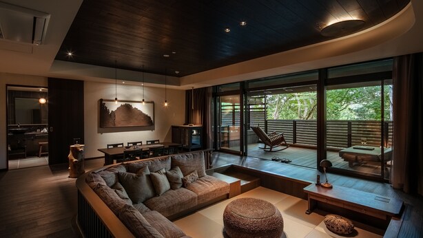 A modern living room with a sectional sofa, a wooden coffee table, and a view of the outdoors. - Fufu Nara (Nara)
