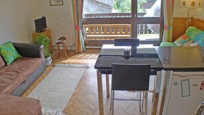 En hyggelig stue med sofa, spisebord og fjernsyn.