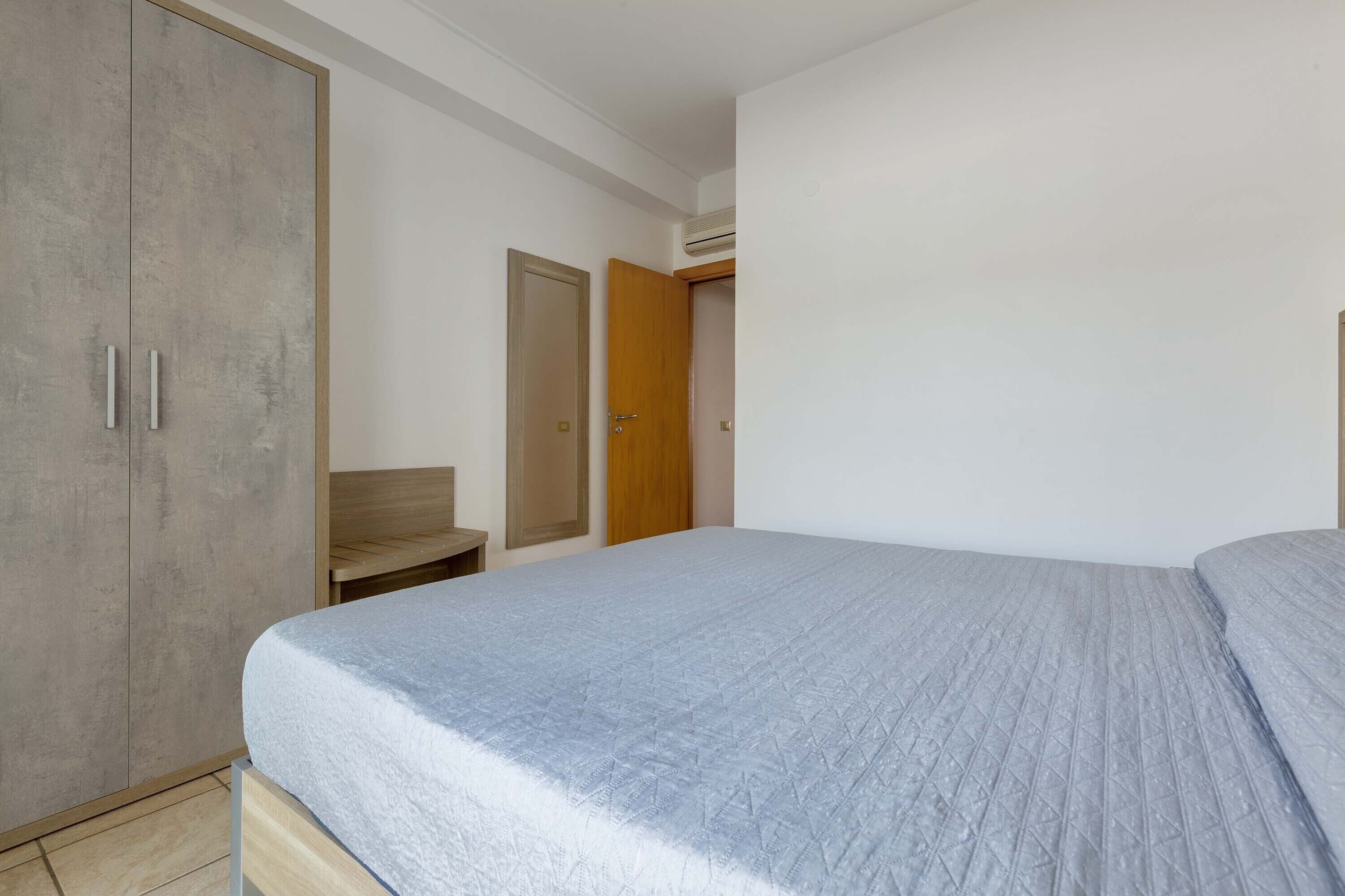 Une chambre à coucher avec un lit, une armoire et un banc en bois.